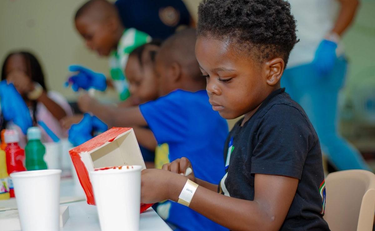 A boy concentrating on an art activity at the classroom table