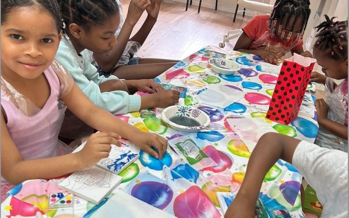 Children painting together around a shared table