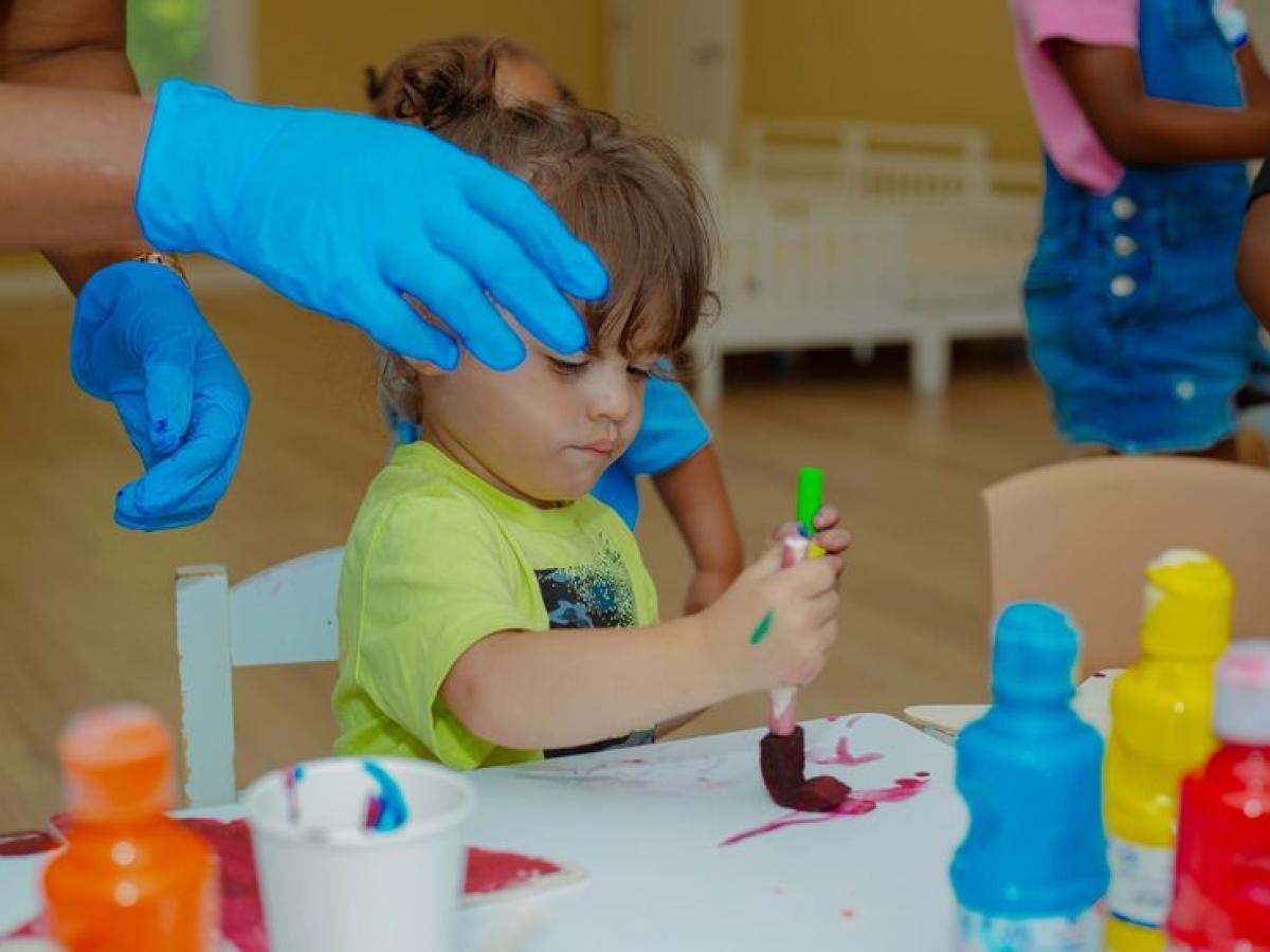 A child mixing paints during a hands-on art session