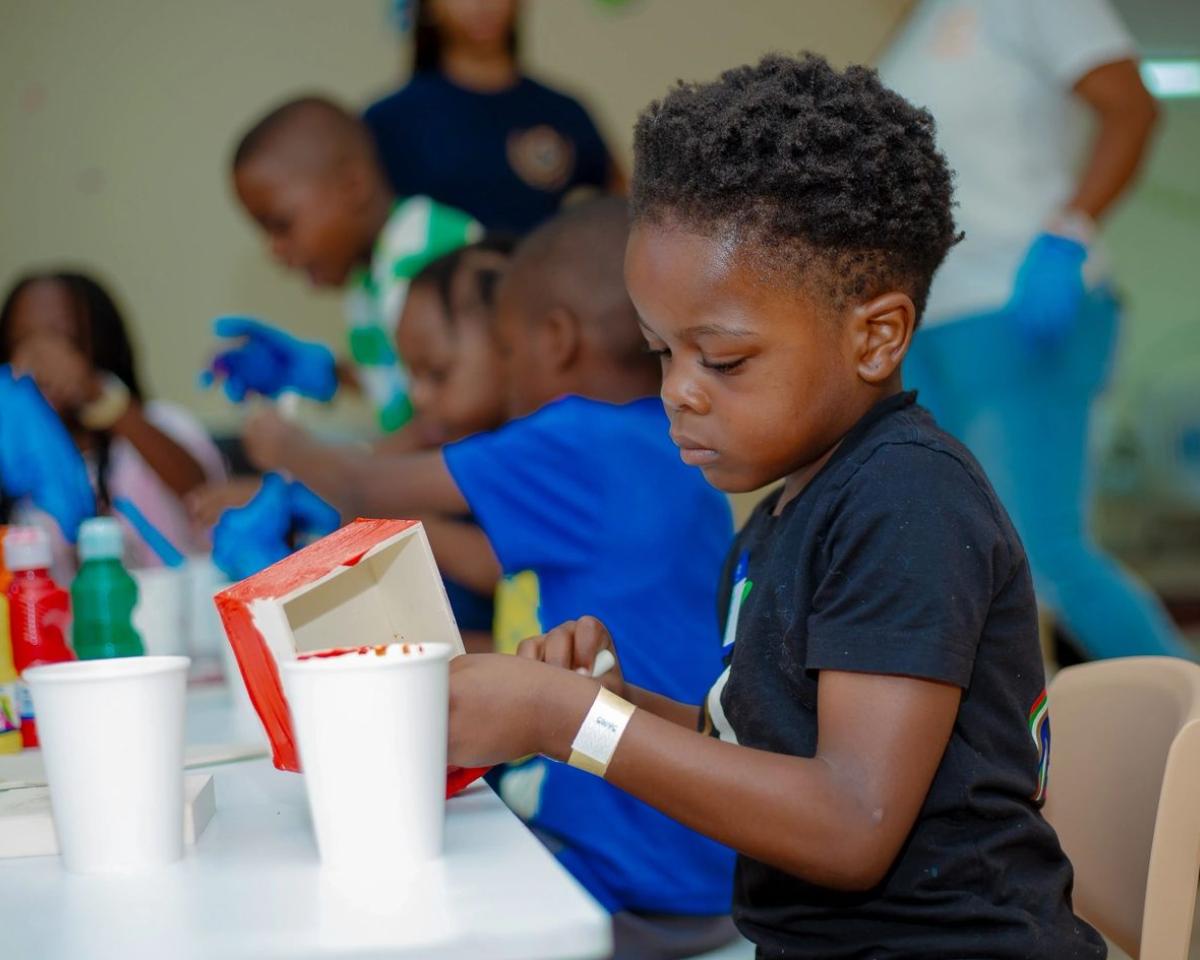 A boy concentrating on an art activity at the classroom table